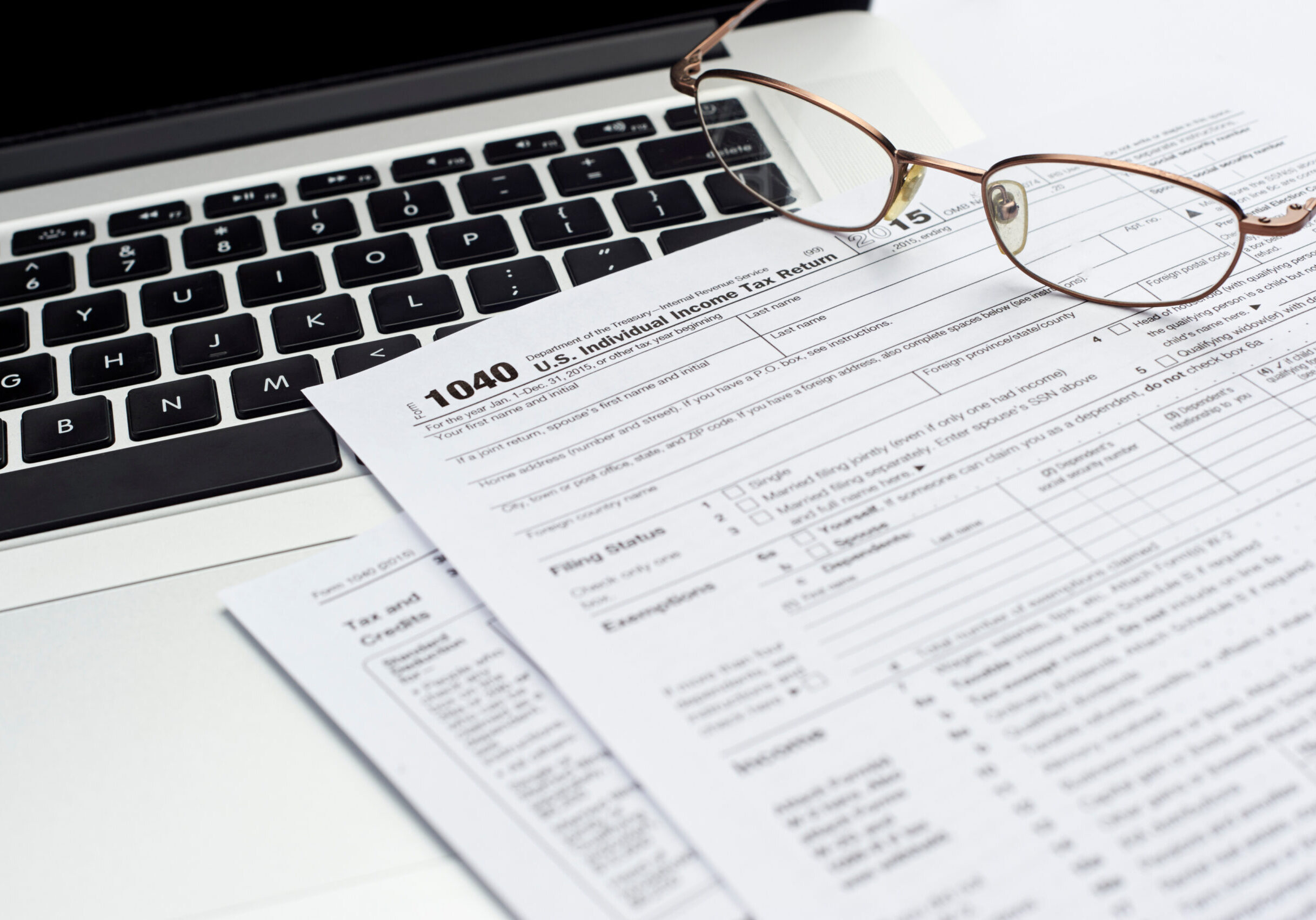 U.S. 1040 income tax return form with laptop and glasses