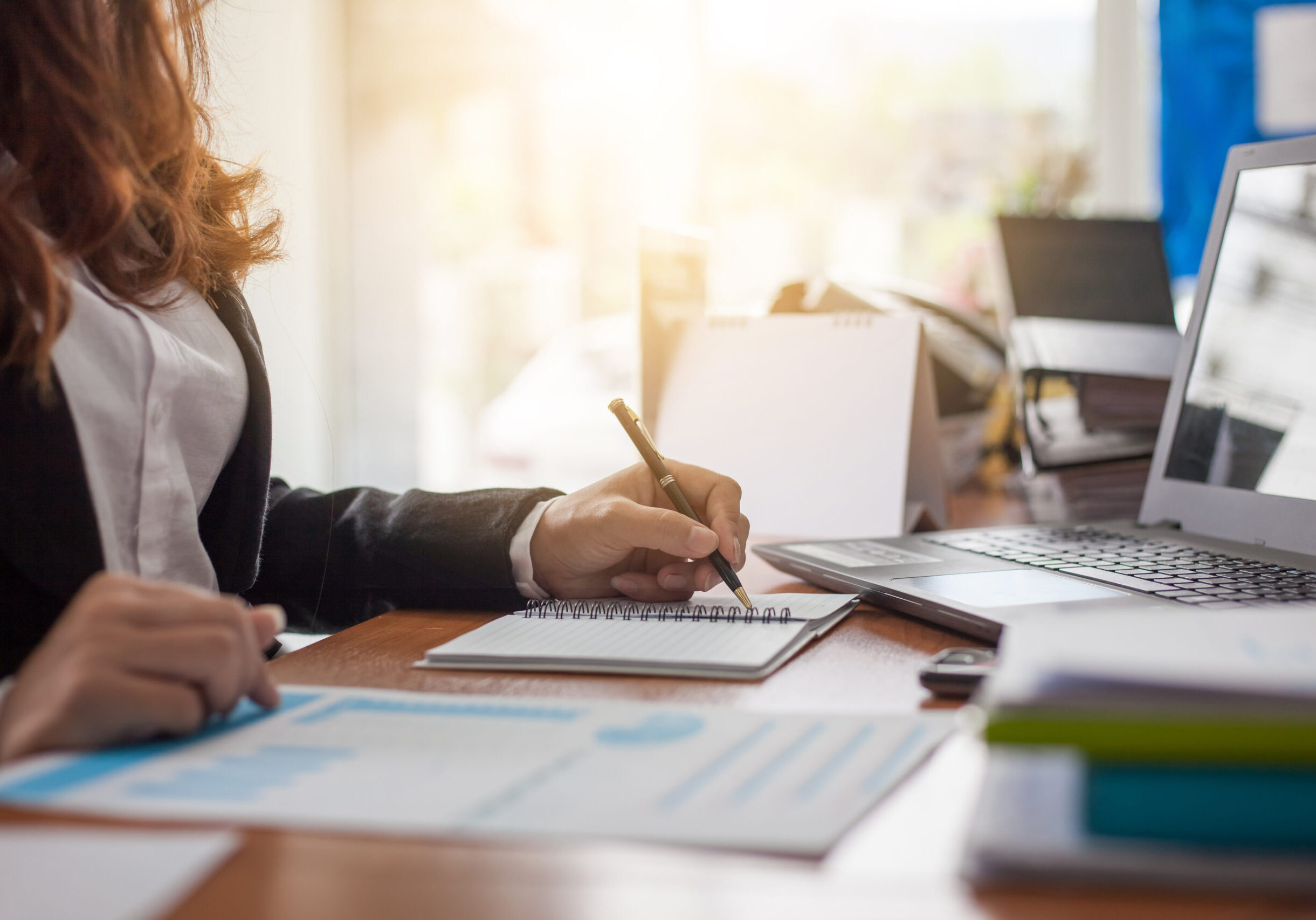Business woman at working with financial reports and laptop computer in the office